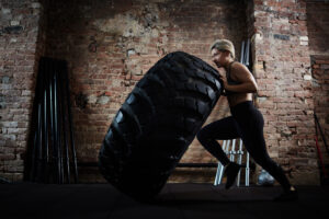 Woman flipping a large tire during a cross-training workout