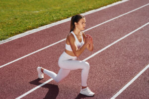 Young woman doing squats as part of concurrent training outdoors.