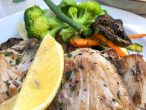  A photo of a healthy and lean dinner plate with grilled fish, roasted vegetables, and a side salad.