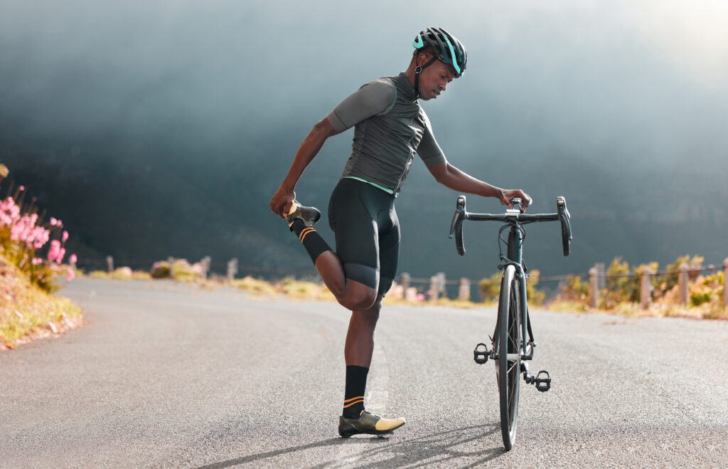 Black man, road and bicycle stretching, fitness or marathon training exercise, triathlon sports and.