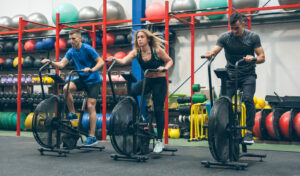 Group of athletes doing air bike at the gym