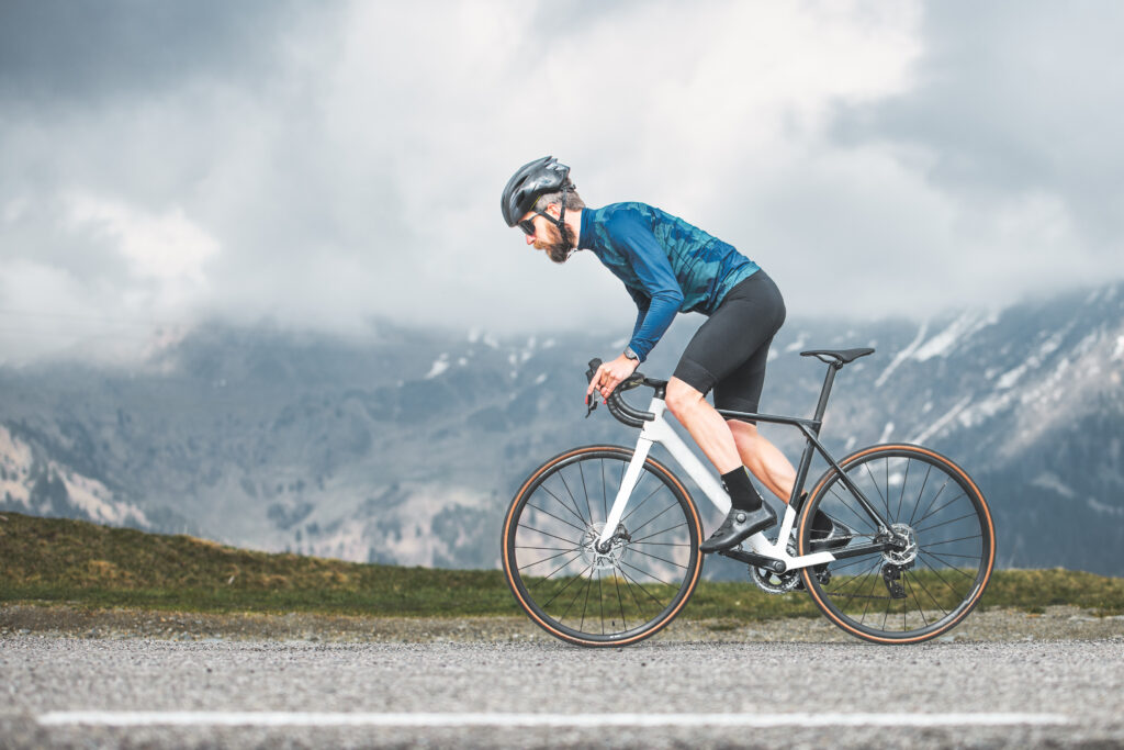 Cyclist climbing a steep hill, symbolizing the challenge and performance aspect of cycling