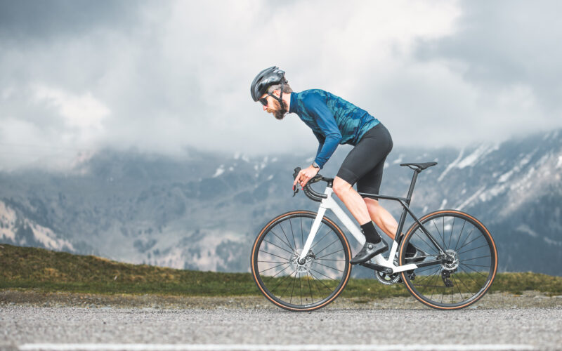 Cyclist climbing a steep hill, symbolizing the challenge and performance aspect of cycling